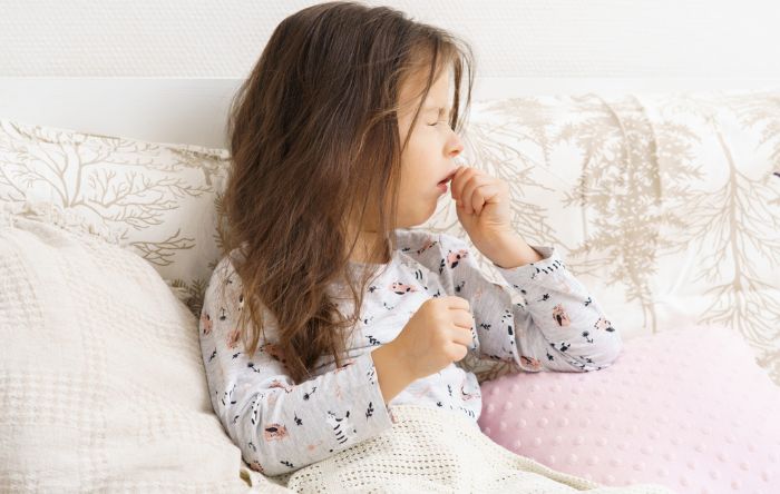 Criança tossindo na cama
